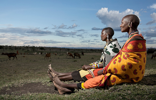 Maasai women looking on their herd (Maasai Mara - Kenya - 2013)