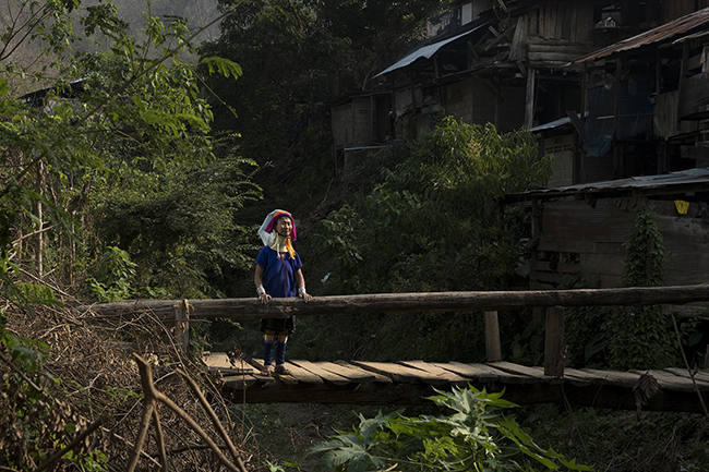 Since the start of the Covid-19 pandemic, Mu Kle, 67, does not leave her house much except for her morning walk around the village. The oldest woman in Huai Pu Kaeng, whose head seems to float above her metal rings, prefers to save her strength in case tourists come to the village.