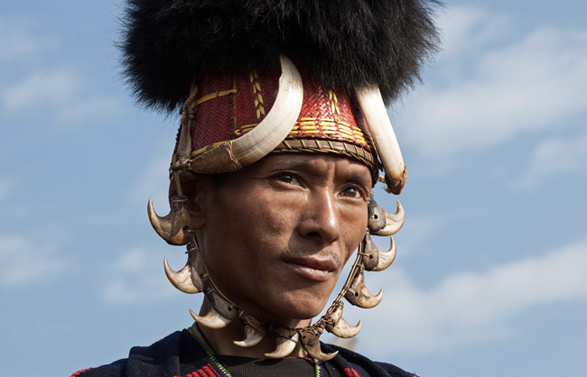 Khiamniungan Naga warrior with traditional hat orned by 2 wild pig's teeth and a set of tiger's teeth.