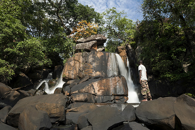 The geology of the Moyen-Bafing National Park in Guinea is mainly composed of sandstone, interbedded with limestone and silica. Natural erosion caused by water flow and wind has shaped unique landscapes, characterized by the interlocking of rocks of various sizes, as seen here at the Dansokoya Falls.