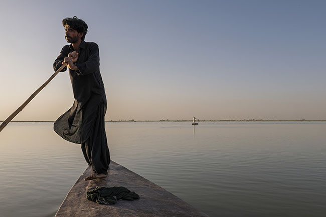 ﻿Mohamed propels his Hurro, the Mohana’s sleek traditional canoe, across the waters of Lake Manchar.
