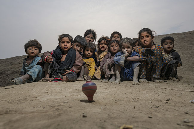 Mohana children are hypnotized by a spinning top. For the Mohana children, simple games become a refuge, laughter, a form of resistance.