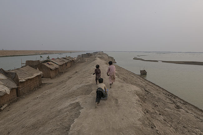 Three Mohana children playing with an empty can on the elevated banks of the RBOD. For Mohana children, simple games become refuge, and laughter, resistance.