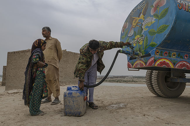 A young Mohana girl fills a canister at one of the few potable water cisterns installed on the shores of the lake.