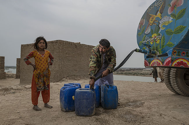 A young Mohana girl fills a canister at one of the few potable water cisterns installed on the shores of the lake.