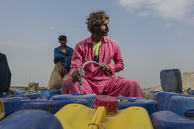 During potable water distributions, everyone waits their turn to fill their canisters. First come, first served. Here, on the shores of Lake Manchar, every drop of potable water is a treasure, every canister a victory.