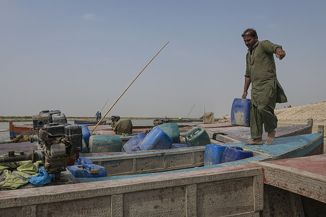 On foot or by boat, once the canisters are filled with potable water, they must still be carefully brought back to the homes.