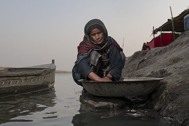 Nayla washes the family laundry in the Right Bank Outfall Drain (RBOD). Clean water being strictly reserved for drinking and cooking, the polluted water must still be used for everything else: laundry, bathing, dishwashing.