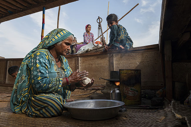 In the hold, Asna prepares the chapati dough. These flatbreads made from flour and water, cooked over a wood fire on a cast-iron plate, are the staple food of the Mohana people.