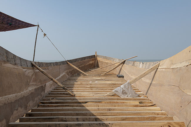 The structure of a traditional boat is being assembled on a shipyard at the edge of Lake Manchar. Each hull is shaped in the continuation of an ancestral craft.