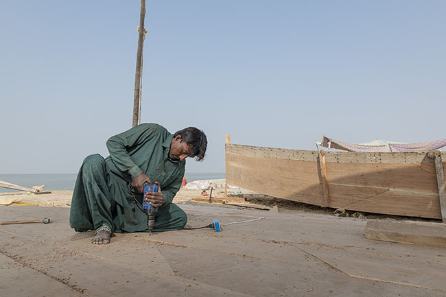 A Mohana boatman hard at work in a shipyard on the shores of Lake Manchar.