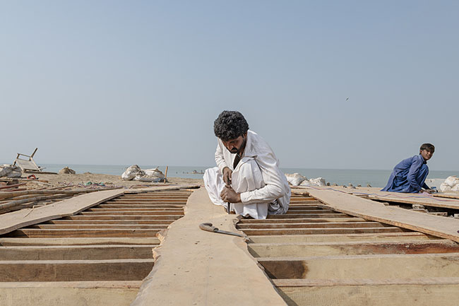 On the shores of Lake Manchar, a Mohana boatman is busy at a shipyard.