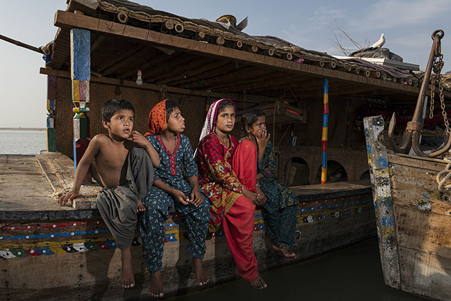 Mohana children sitting on the edge of their houseboat. For centuries, members of the Mohana tribe have lived aboard Galiyo, their traditional floating dwellings. But today, most have left the serenity of the lake to join the many settled Mohanas ashore.