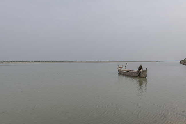 Yusuf, 58, a Mohana fisherman, casts his nets in the waters of the Indus River. Once settled by Lake Manchar, he now lives in a small village where he has resettled with his family.